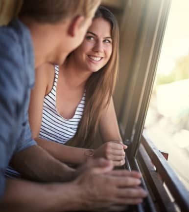 Hombre con una mujer cerca de una ventana conversando
